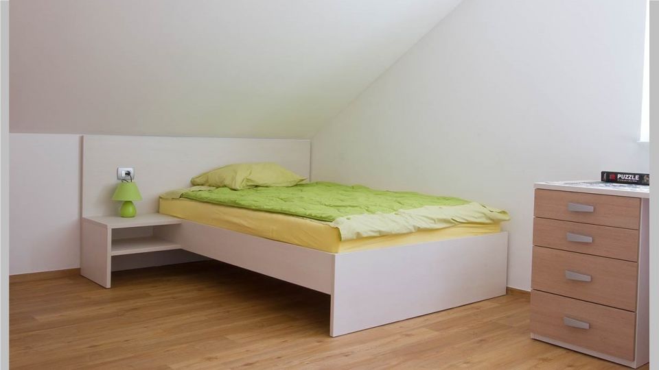 Akron postelja, model Klasik s predali ali brez. Širina od 80 do 200 cm, dolžina do 220 cm. Možno je prilagoditi ležalno višino. Vzglavje klasično leseno ali oblazinjeno.